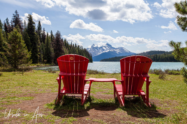 Red Adirondack chairs on the shore of Maligne Lake, Jasper Alberta Canada