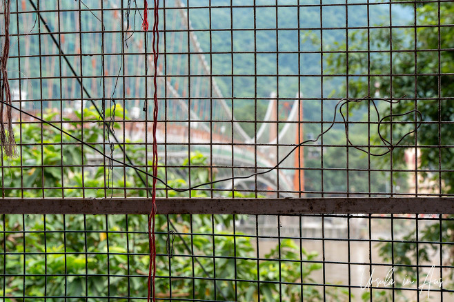 The colourful curves of Ram Jhula through a metal fence, Rishikesh, India