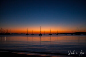 Pink and red sunset over sailboats in Naoussa Harbour, Paros Greece