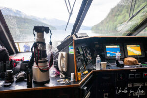 Canon camera with a long telephoto lens on the bridge of a boat, Khutzeymateen Chanel, BC Canada