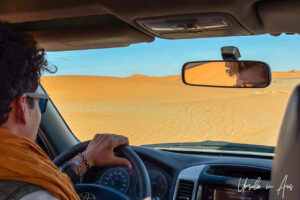 View of sand through the wind screen of a car, Erg Chebb, Morocco.
