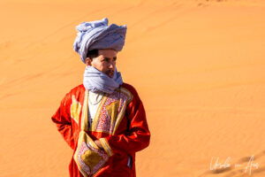 Man in large blue turban against the sands of Erg Chebb, Morocco.