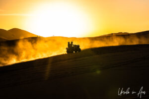 Dune buggy silhouetted against a Sahara sunset, Erg Chebb, Morocco.