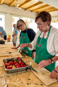 Women pouring oil over filled capsicum, Platia, Naxos Greece