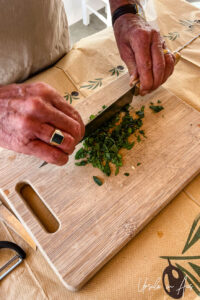 Close-up: hands chopping green herbs, Platia, Naxos Greece