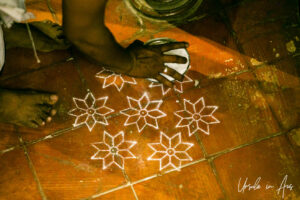 White dusted flowers stamped on the floor, Great K V Kathakali Center in Fort Kochi, Kerala India