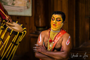 Man in yellow paint demonstrating eye movements, Great K V Kathakali Center in Fort Kochi, Kerala India