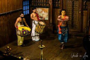 Man in yellow paint demonstrating foot movements, Great K V Kathakali Center in Fort Kochi, Kerala India