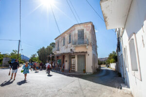 People walking in a Halki Street under a bright sun, Naxos Greece.