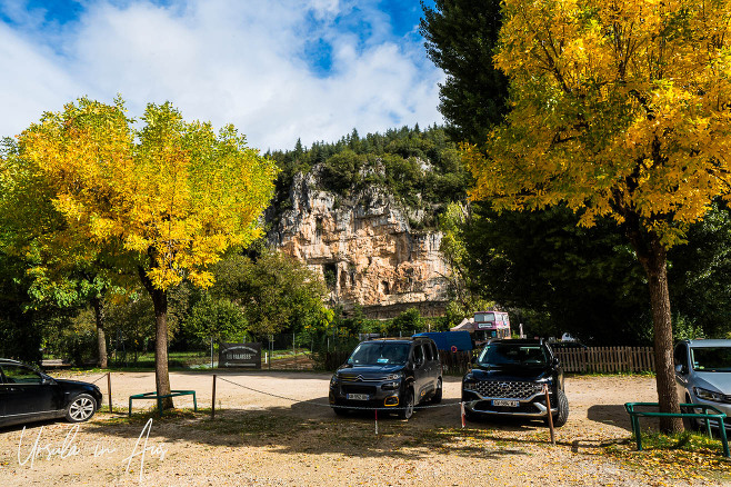 Cars parked under yellow autumn trees, Bouziès France.