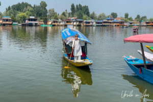 A man standing and rowing on Dal Lake, Jammu and Kashmir, India