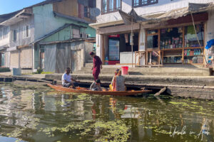 People with bags on a long rowboat, Dal Lake, Jammu and Kashmir, India