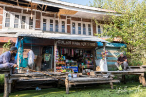 Men on the pier outside a small shop front, Dal Lake, Jammu and Kashmir, India