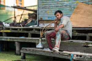 Young man smoking a water pipe, Dal Lake, Jammu and Kashmir, India