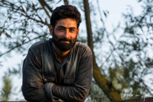 Environmental portrait: A handsome Kashmiri man with trees behind, Dal Lake, Jammu and Kashmir, India