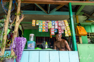 A Papuan shopkeeper and his shop window, Kwatisore, Papua Indonesia