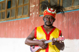 Papuan musician in traditional costume, Kwatisore, Papua Indonesia