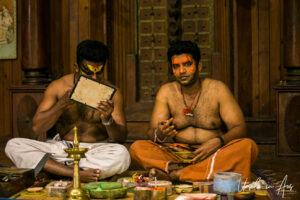 Two seated men applying face paint, Kerala Kathakali Centre, Fort Kochi, India