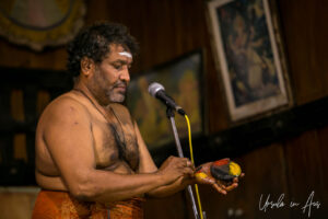Man explaining makeup colours, Kerala Kathakali Centre, Fort Kochi, India