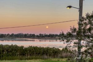 Full moon in a pink sky over Lake Curalo, Eden Australia.