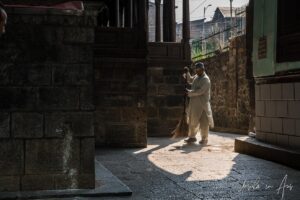 A man sweeping in a patch of light, Shah E Hamdan Mosque, Srinagar, Jammu and Kashmir, India.