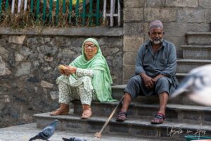A seated couple in the front courtyard, Shah E Hamdan Mosque, Srinagar, Jammu and Kashmir, India.