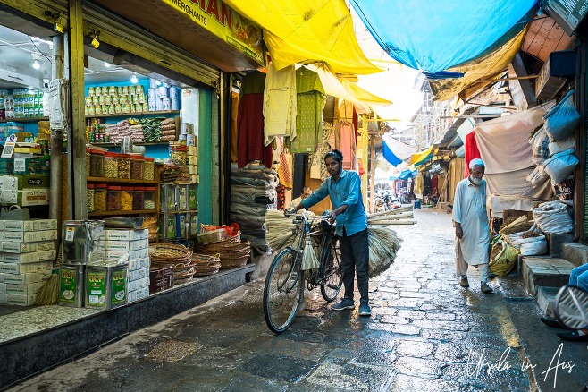 Young man with brooms on a bicycle, Srinagar Nowhatta, Jammu and Kashmir, India. 