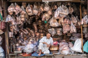 Man sitting surrounded by copper pots, Srinagar Nowhatta, Jammu and Kashmir, India.