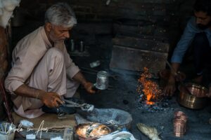 Metal worker in a dark workspace, Srinagar Nowhatta, Jammu and Kashmir, India.