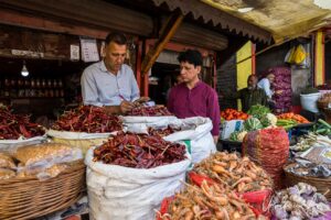 Men negotiation behind bags of spices, Srinagar Nowhatta, Jammu and Kashmir, India.
