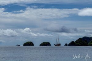Silhouetted boats and islands in the distance, Pulau Wayag, Southwest Papua Indonesia