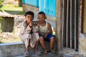 Environmental portrait: two young boys on the front step of a house, Doom, Southwest Papua, Indonesia.