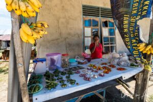 Papuan woman with fruit and vegetables for sale, Doom, Southwest Papua, Indonesia.