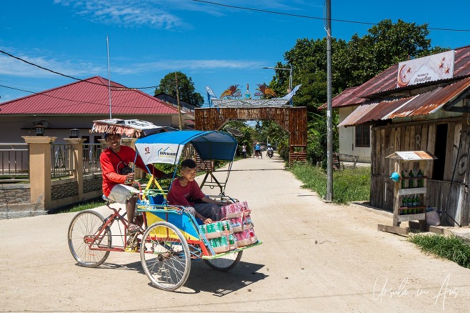 Man and boy in a pedicab of soft drink, Doom, Southwest Papua, Indonesia.