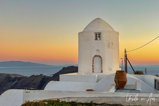 White windmill in pink morning light, Fira Santorini Greece
