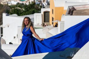 Woman in a formal blue gown, Oia, Santorini Greece.