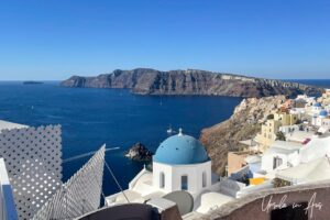 Dome of an Orthodox church with the Santorini caldera in the background, Oia Greece.