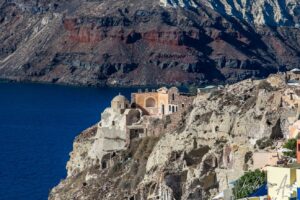 Old church and other buildings on a rocky promontory, Oia, Santorini Greece.