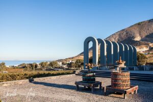 Modern sculpture and old equipment at the entry to the Estate Argyros, Santorini Greece