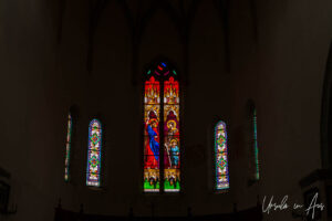 Stained glass windows in the dark interior, Saint-Cirq Lapopie Church, France