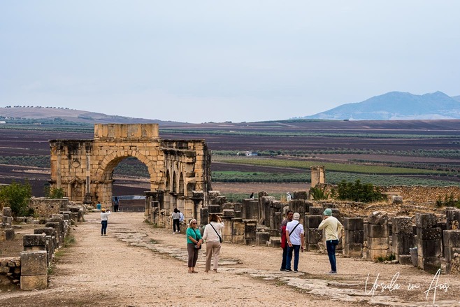 People on the Roman road in front of the Arch Of Caracalla, Volubilis Morocco