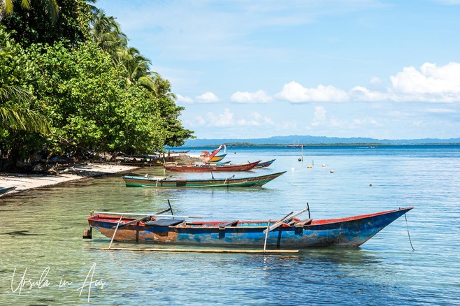 Outrigger canoes on still blue waters, Coral Triangle, Pulau Soop Indonesia