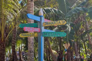 Colourfully painted sign pointing to Indonesian locations, Pulau Soop Indonesia
