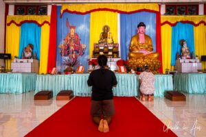 A kneeling woman in prayer, Sapta Ratna Pagoda, Sorong, Indonesia