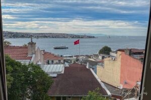 View towards Asia across the Bosphorus with a Turkish flag flying over the rooftops, Istanbul.