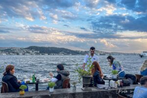 Serving man against the Bosphorus in a waterfront restaurant, Ortaköy Türkiye