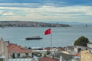 View towards Asia across the Bosphorus with a Turkish flag flying over the rooftops, Istanbul.