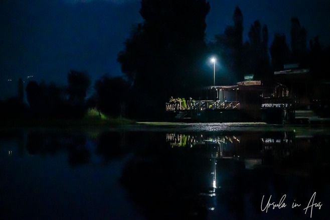 Single light over a houseboat on Dal Lake in the dark, Srinagar, Kashmir India.