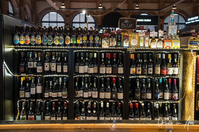 Shelves of bottles at the entry to La Halle Cahors, France.