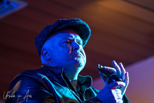 Stage portrait: Dan Sullivan holding his harmonica, Thredbo Lounge Bar, Australia